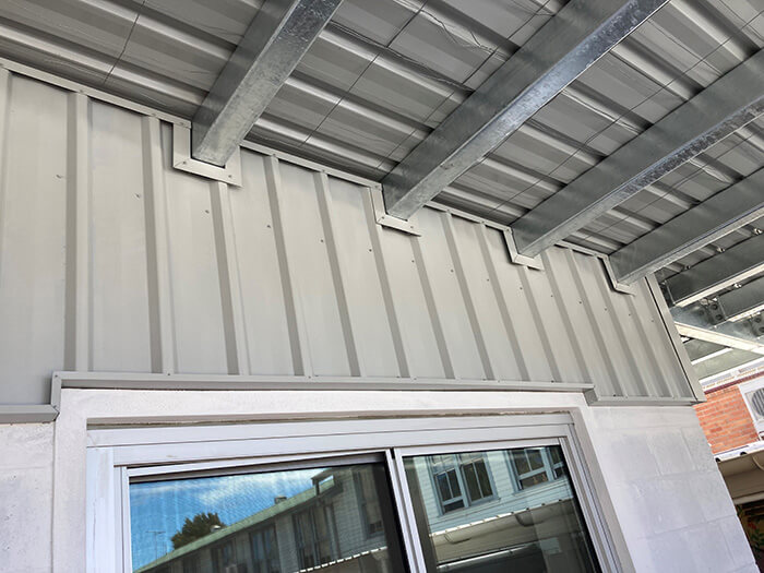 Neat and orderly flashing on steel roof beams entering a wall